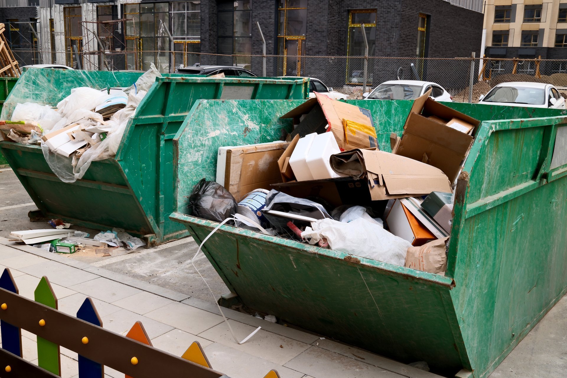 Overflowing construction dumpster with debris and waste at construction site